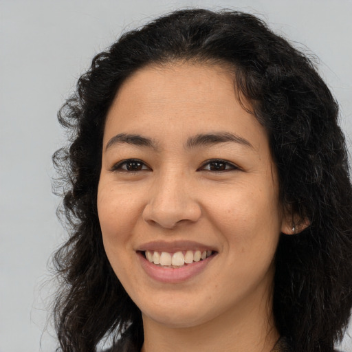 Joyful latino young-adult female with long  brown hair and brown eyes