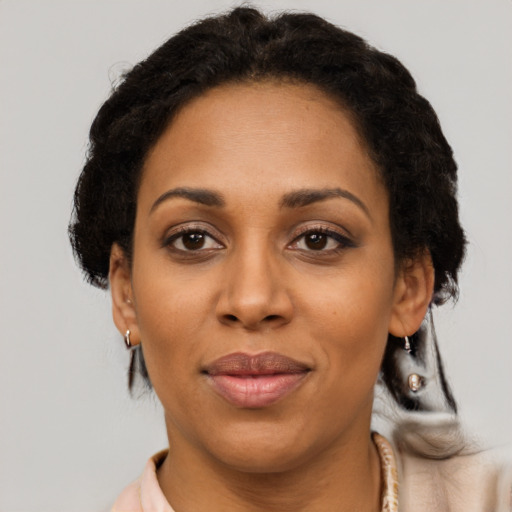 Joyful black adult female with short  black hair and brown eyes