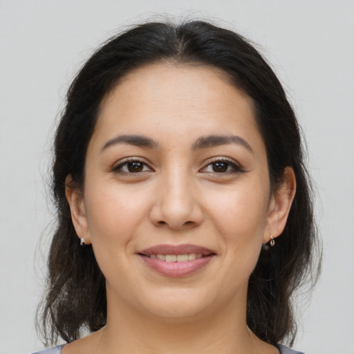 Joyful latino young-adult female with medium  brown hair and brown eyes