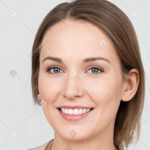 Joyful white young-adult female with medium  brown hair and grey eyes