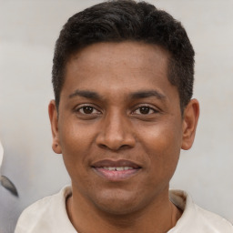 Joyful latino young-adult male with short  brown hair and brown eyes