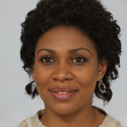 Joyful black adult female with medium  brown hair and brown eyes