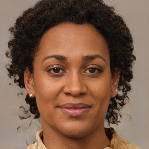 Joyful black adult female with medium  brown hair and brown eyes