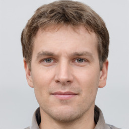 Joyful white young-adult male with short  brown hair and grey eyes