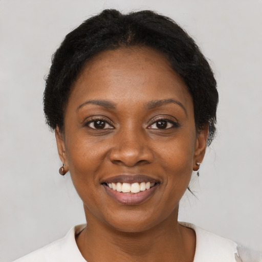 Joyful black young-adult female with short  brown hair and brown eyes
