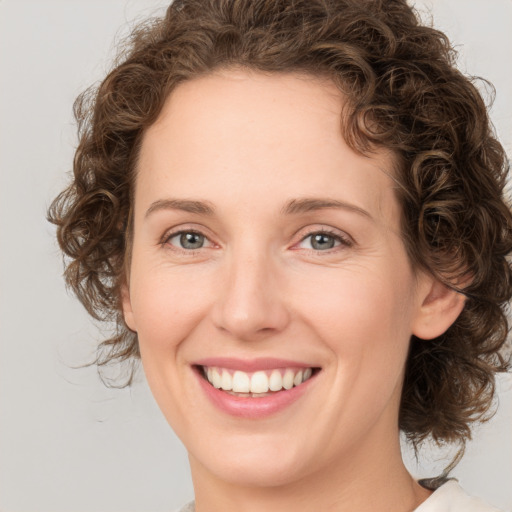 Joyful white young-adult female with medium  brown hair and green eyes