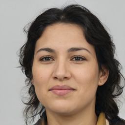 Joyful latino young-adult female with medium  brown hair and brown eyes