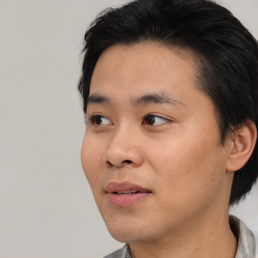 Joyful asian young-adult male with short  black hair and brown eyes
