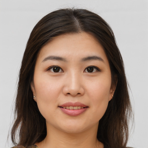Joyful asian young-adult female with long  brown hair and brown eyes