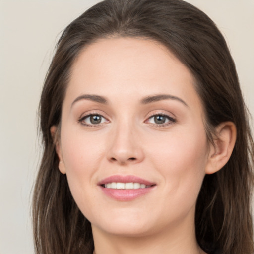 Joyful white young-adult female with long  brown hair and grey eyes