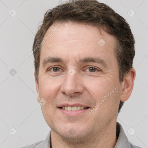 Joyful white adult male with short  brown hair and grey eyes