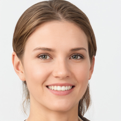 Joyful white young-adult female with medium  brown hair and grey eyes