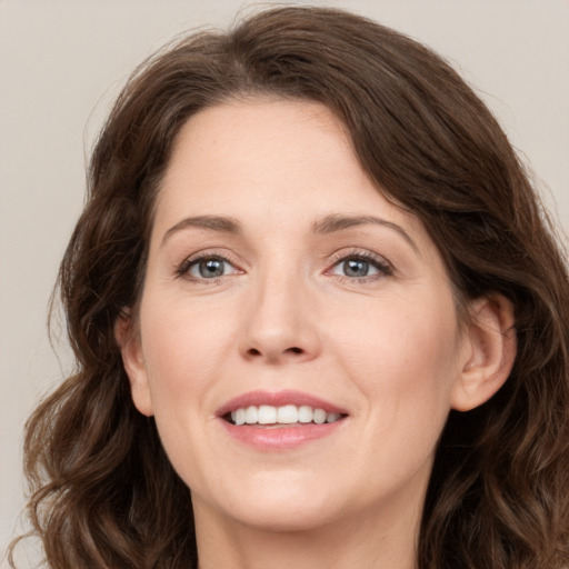 Joyful white adult female with long  brown hair and green eyes