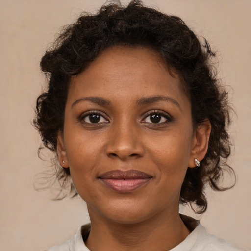 Joyful black young-adult female with medium  brown hair and brown eyes