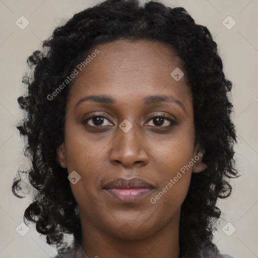 Joyful black young-adult female with long  brown hair and brown eyes