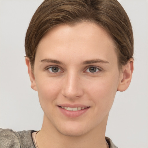 Joyful white young-adult female with short  brown hair and grey eyes