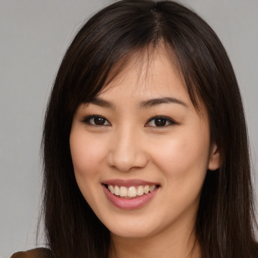 Joyful asian young-adult female with long  brown hair and brown eyes