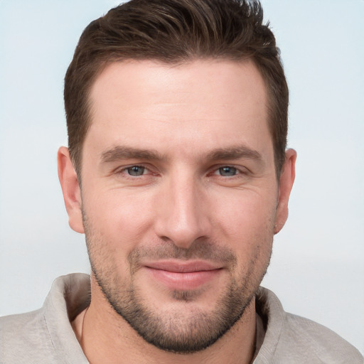 Joyful white young-adult male with short  brown hair and grey eyes