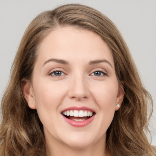 Joyful white young-adult female with long  brown hair and green eyes