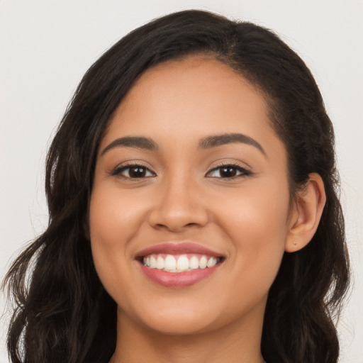 Joyful latino young-adult female with long  brown hair and brown eyes