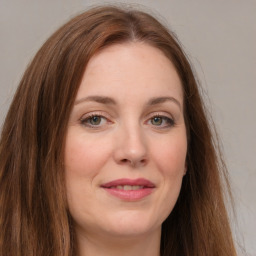 Joyful white young-adult female with long  brown hair and green eyes