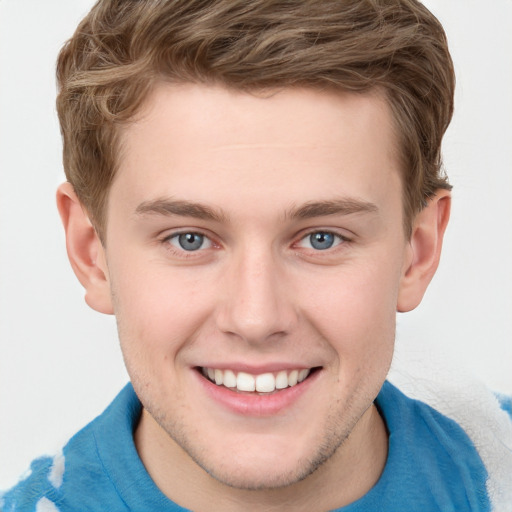 Joyful white young-adult male with short  brown hair and blue eyes