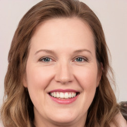 Joyful white adult female with long  brown hair and grey eyes