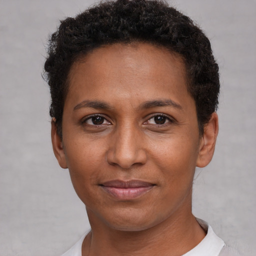 Joyful black young-adult female with short  brown hair and brown eyes