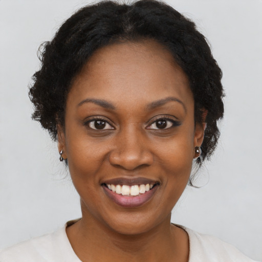 Joyful black young-adult female with short  brown hair and brown eyes
