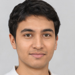 Joyful latino young-adult male with short  brown hair and brown eyes