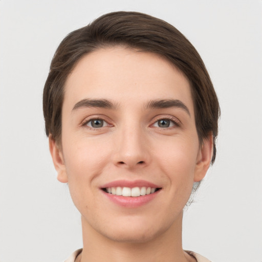 Joyful white young-adult female with short  brown hair and grey eyes