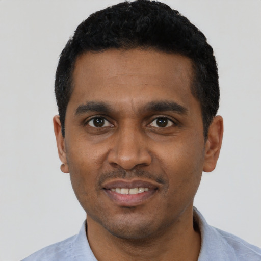 Joyful black young-adult male with short  black hair and brown eyes