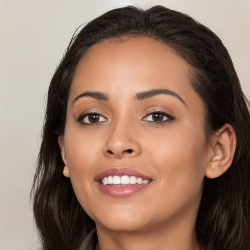 Joyful latino young-adult female with long  brown hair and brown eyes