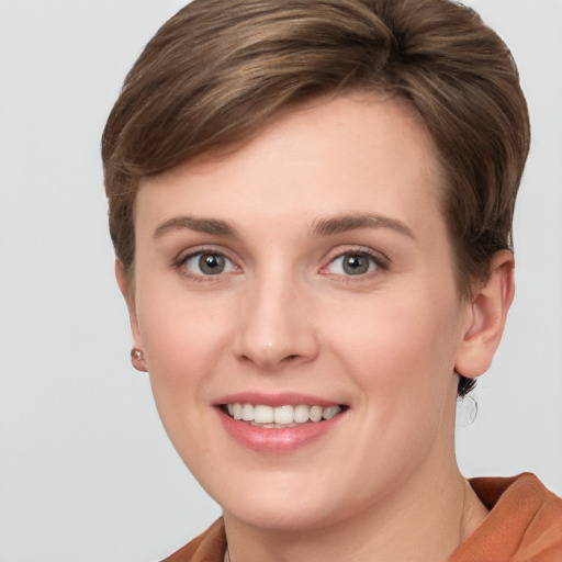 Joyful white young-adult female with short  brown hair and grey eyes