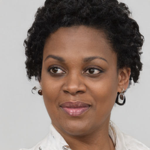 Joyful black young-adult female with short  black hair and brown eyes