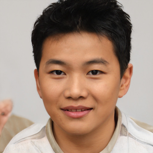 Joyful asian child male with short  black hair and brown eyes