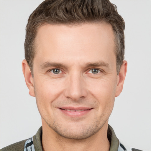 Joyful white adult male with short  brown hair and grey eyes