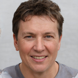 Joyful white adult male with short  brown hair and grey eyes