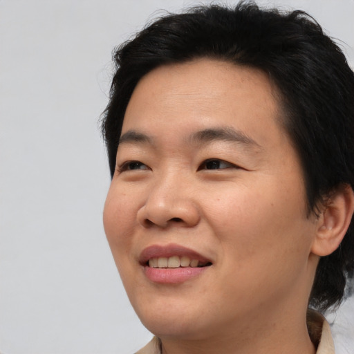 Joyful asian young-adult male with medium  brown hair and brown eyes