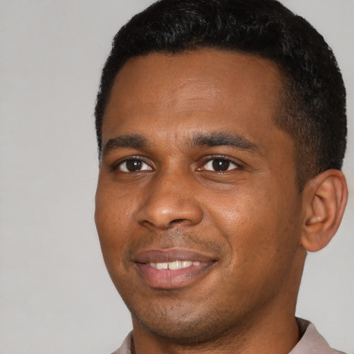 Joyful black young-adult male with short  black hair and brown eyes