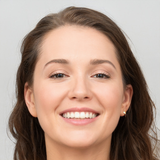 Joyful white young-adult female with long  brown hair and grey eyes