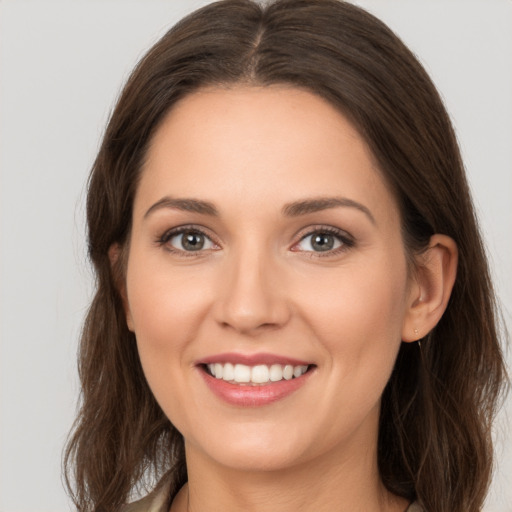 Joyful white young-adult female with long  brown hair and brown eyes