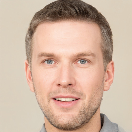 Joyful white young-adult male with short  brown hair and grey eyes