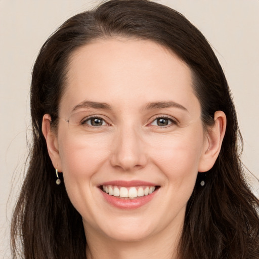 Joyful white young-adult female with long  brown hair and grey eyes