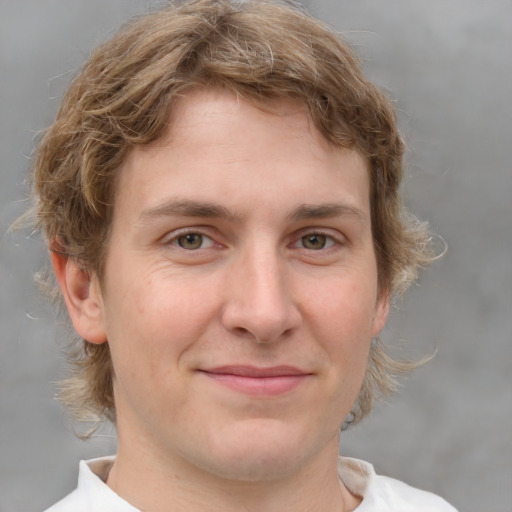 Joyful white young-adult male with medium  brown hair and grey eyes