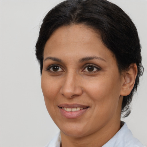 Joyful latino adult female with medium  brown hair and brown eyes