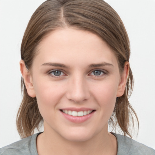 Joyful white young-adult female with medium  brown hair and grey eyes