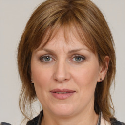 Joyful white adult female with medium  brown hair and grey eyes