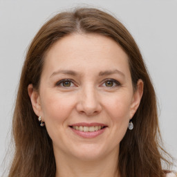 Joyful white adult female with long  brown hair and grey eyes