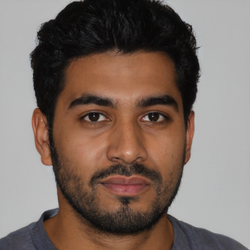 Joyful latino young-adult male with short  black hair and brown eyes